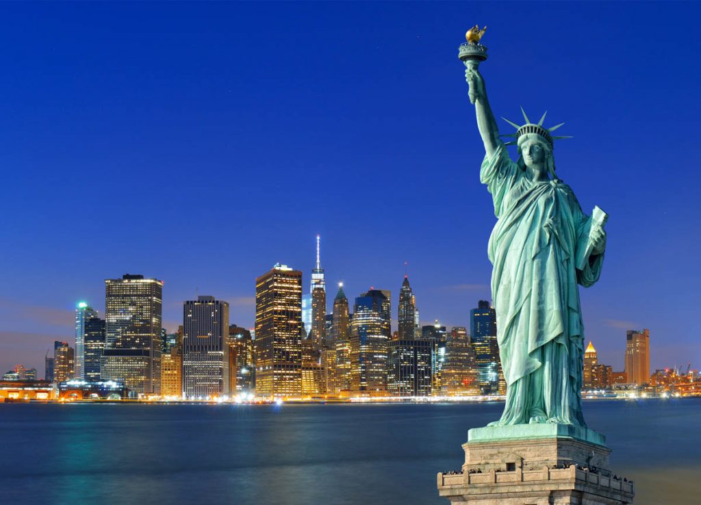 Manhattan skyline at night and Statue of Liberty.