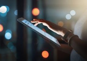 Cropped shot of an unrecognizable businesswoman using a digital tablet while working late