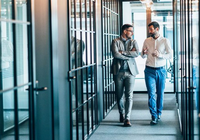 Business partners in discussion walking in office